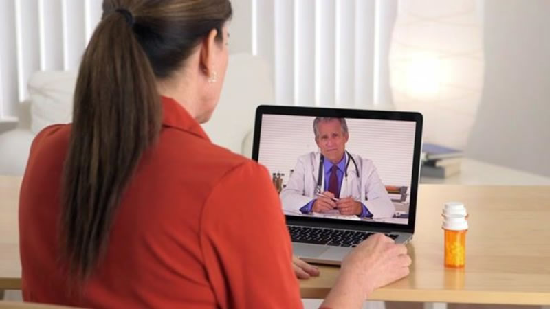 woman discussing symtoms with a doctor over video conference